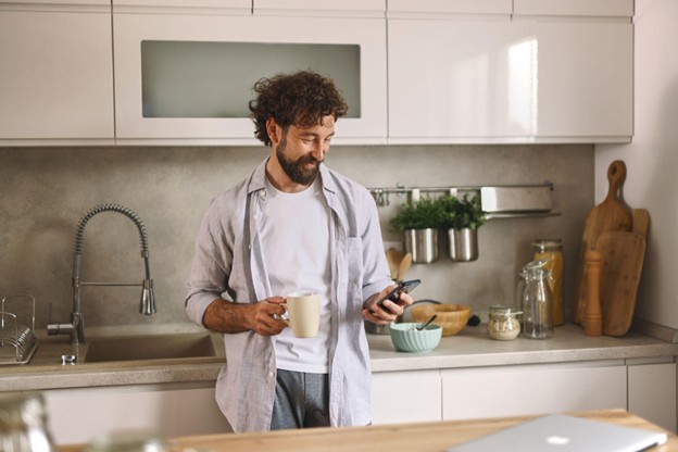 Man Standing In Front of an Apartment Kitchen