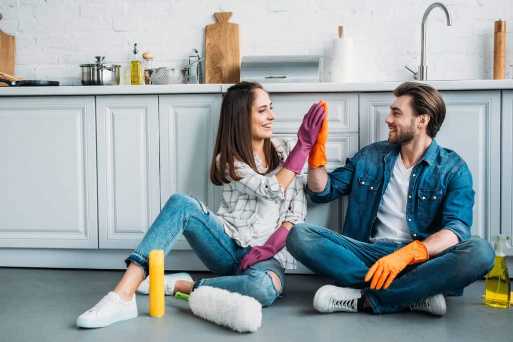 A Couple Finishing Deep Cleaning Their Apartment Kitchen